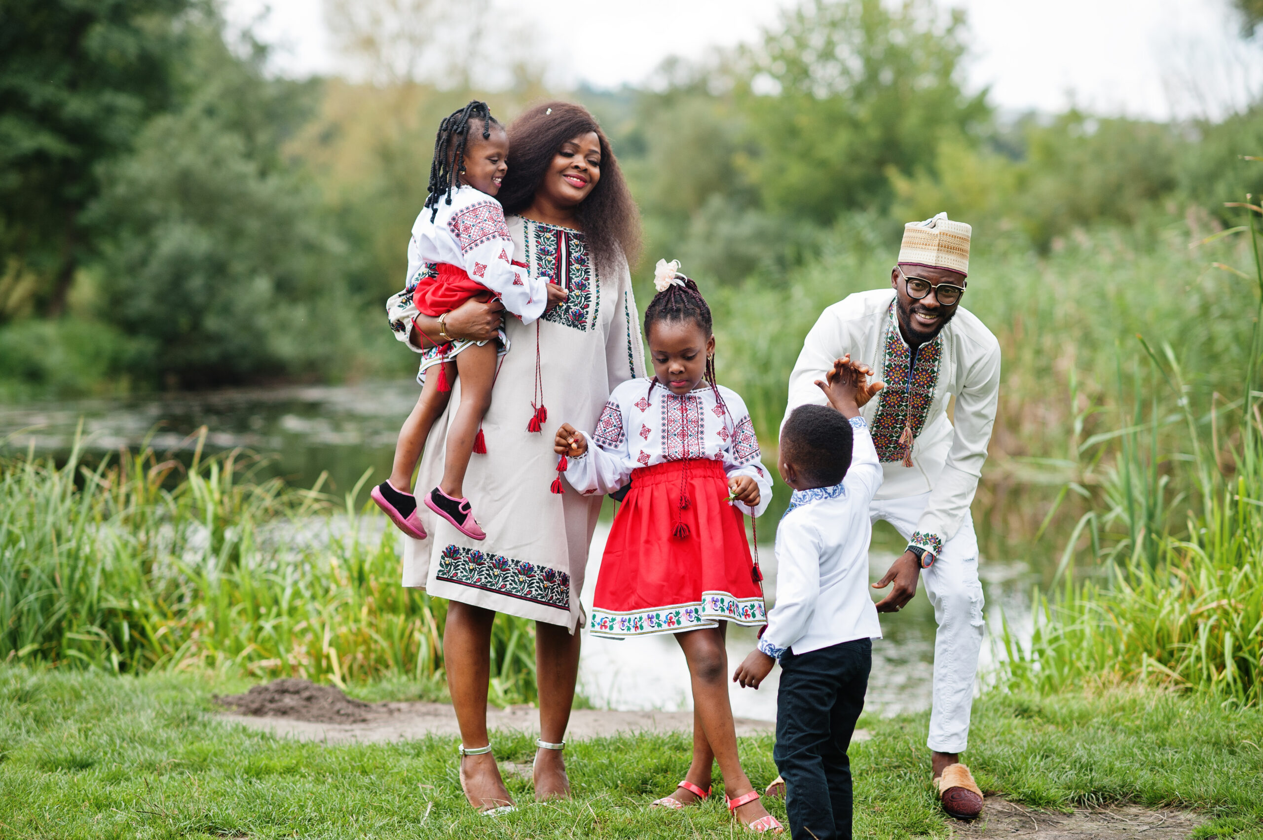 african family in traditional clothes at park.